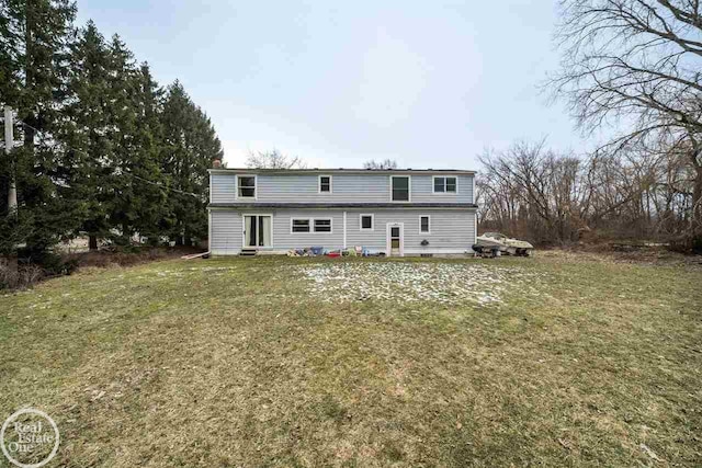 rear view of property featuring a lawn