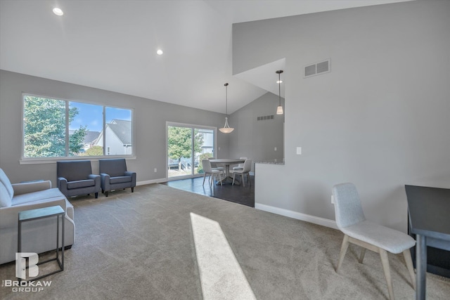 carpeted living room featuring high vaulted ceiling