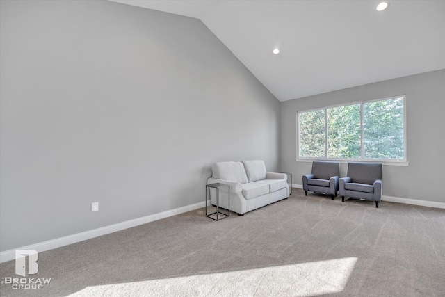 living area featuring light carpet and vaulted ceiling