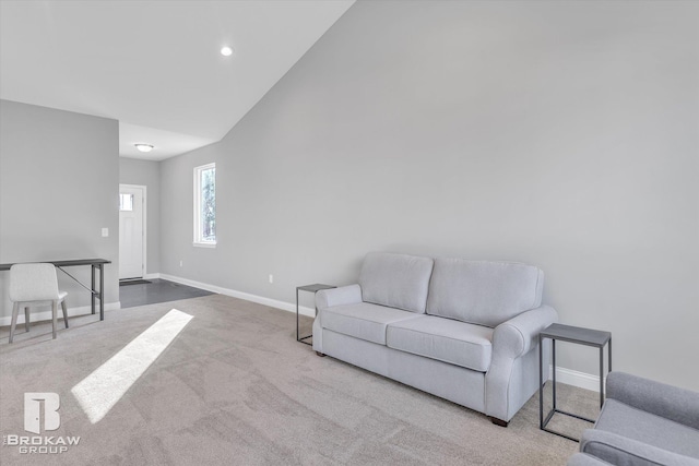 carpeted living room with high vaulted ceiling