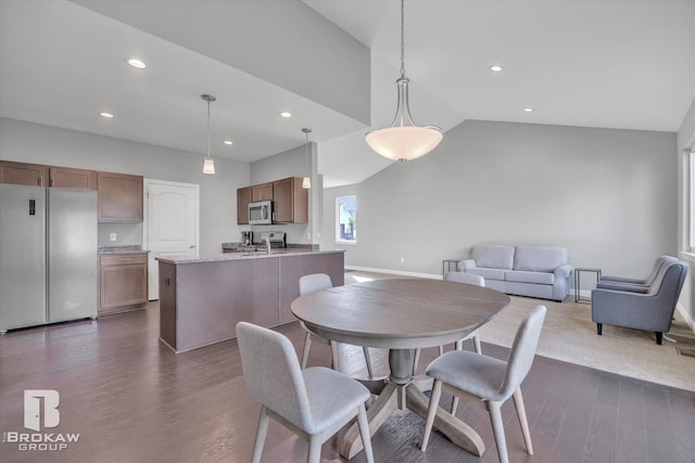 dining room with high vaulted ceiling and dark wood-type flooring