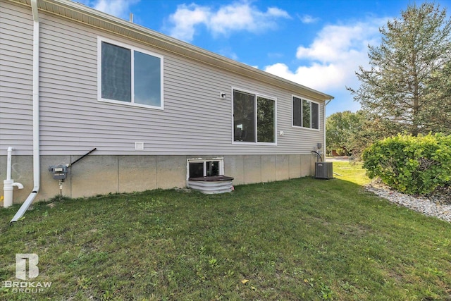 rear view of property featuring central AC and a yard