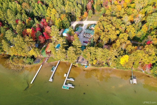 drone / aerial view featuring a water view and a wooded view