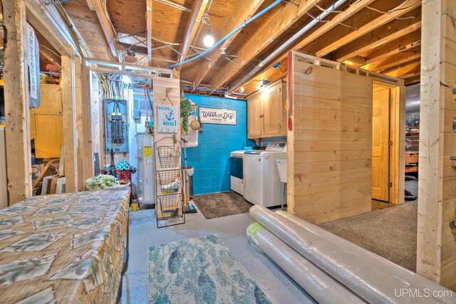 unfinished below grade area with washing machine and dryer, electric water heater, and concrete block wall