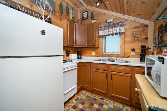 kitchen featuring lofted ceiling, wooden walls, wooden ceiling, and white appliances