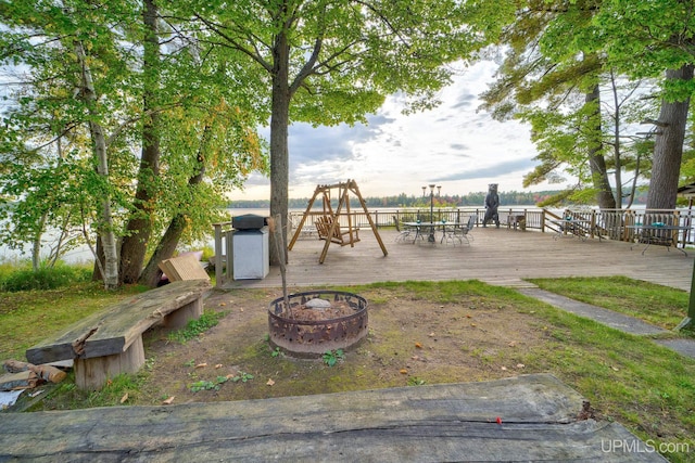 view of yard featuring a fire pit, a deck, and outdoor dining space