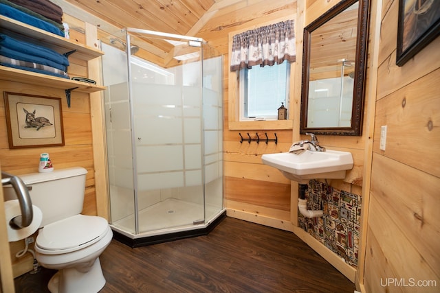 bathroom with lofted ceiling, toilet, wooden walls, a shower with door, and hardwood / wood-style floors