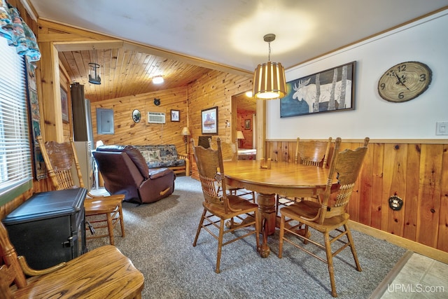 dining room featuring carpet floors and wood walls