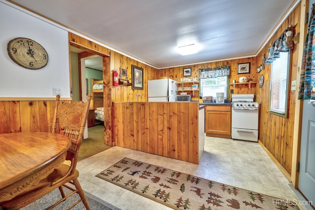 kitchen with white appliances and wood walls