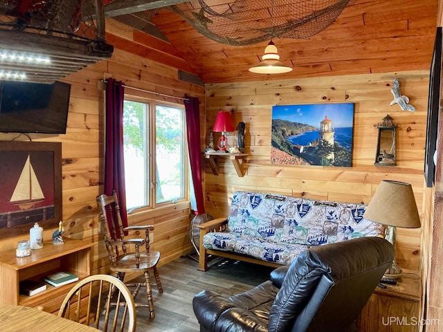 living room with hardwood / wood-style flooring, lofted ceiling, and wooden walls