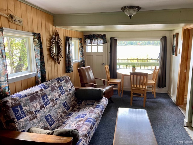 carpeted living room with wood walls