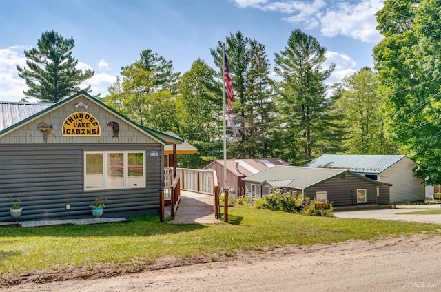 view of front of house with log veneer siding and a front yard