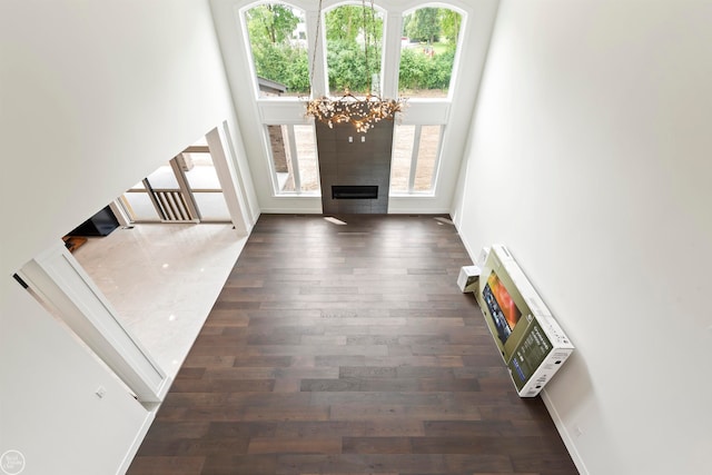 foyer with a tiled fireplace, dark hardwood / wood-style floors, and a chandelier