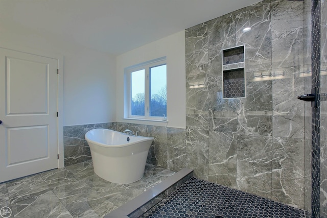 bathroom with tile flooring, tile walls, and shower with separate bathtub