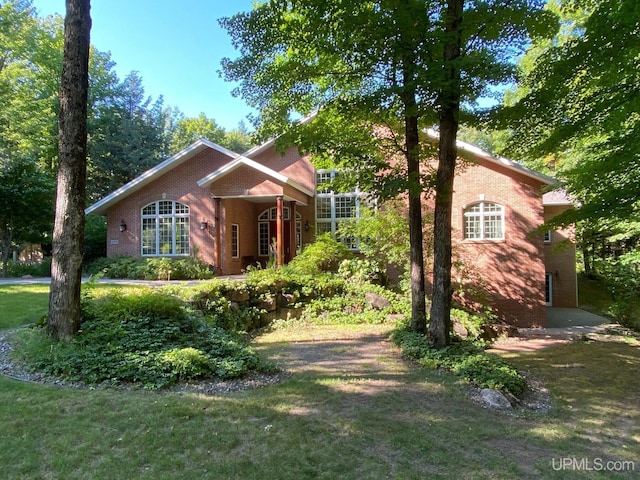 view of front of home with a front lawn and brick siding