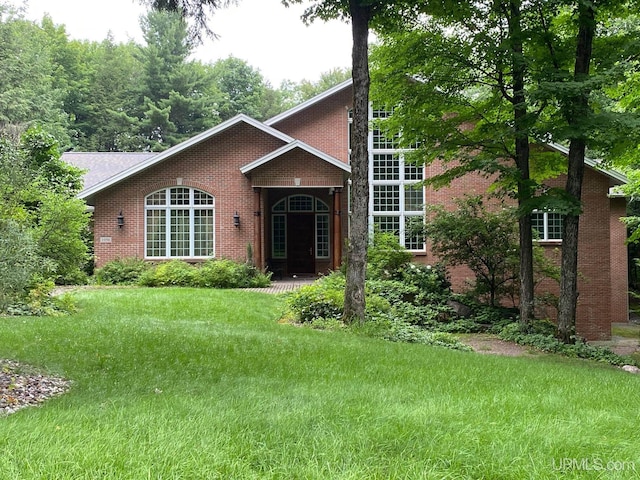 view of front facade featuring brick siding and a front lawn