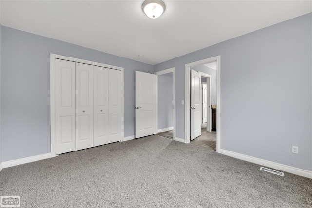 unfurnished bedroom featuring a closet and dark carpet