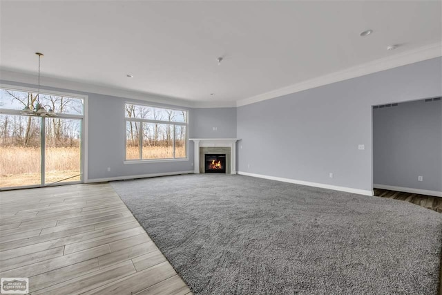 unfurnished living room with ornamental molding, a chandelier, and light wood-type flooring