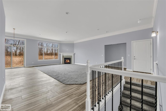 living room with a notable chandelier, crown molding, and light wood-type flooring