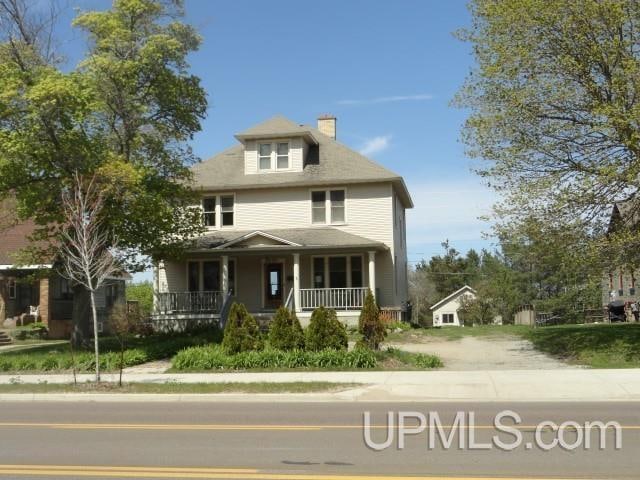 traditional style home featuring a porch and a chimney