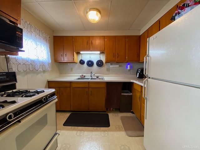 kitchen featuring white appliances, sink, light tile floors, and tasteful backsplash