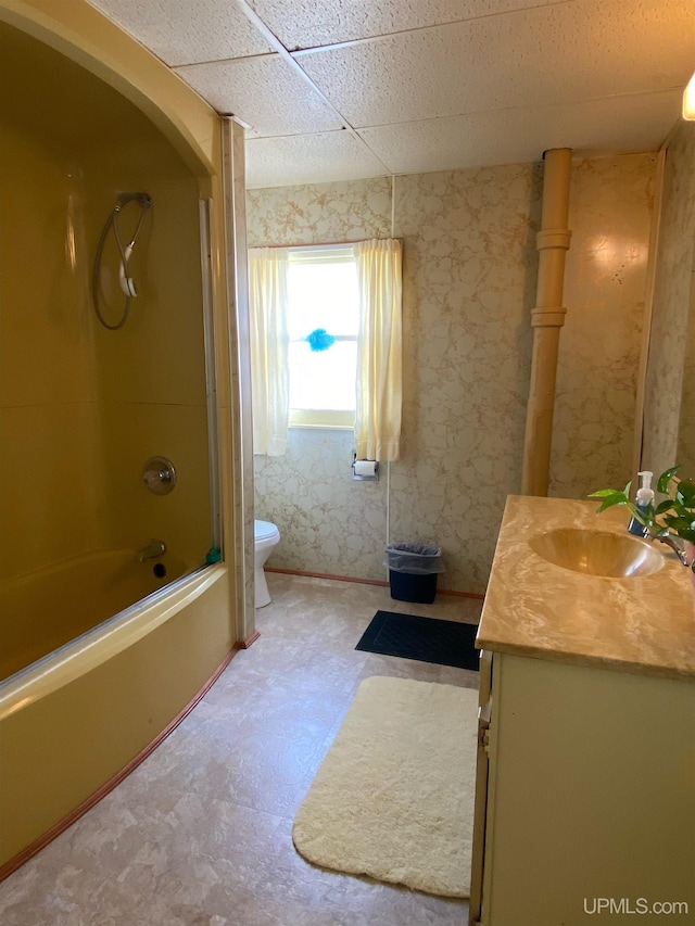 full bathroom with vanity,  shower combination, a paneled ceiling, tile flooring, and toilet