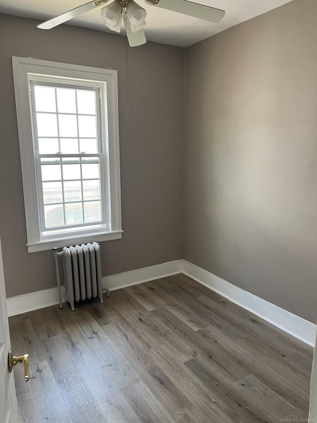 unfurnished room with wood-type flooring, radiator heating unit, and ceiling fan