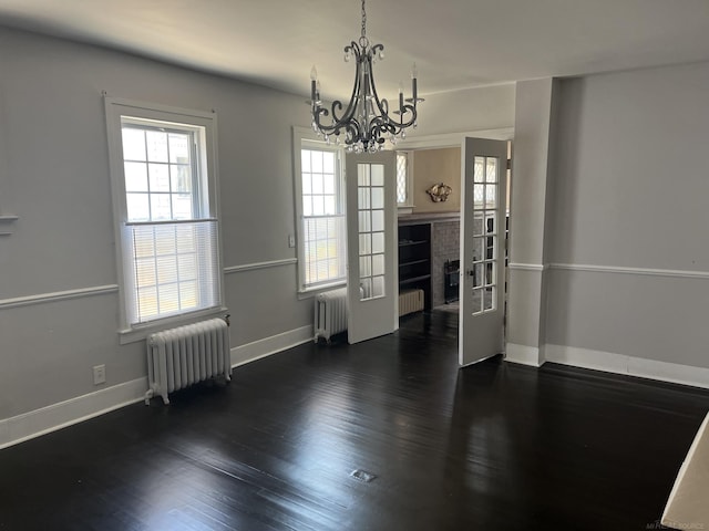 unfurnished dining area with a healthy amount of sunlight, radiator, and dark hardwood / wood-style flooring