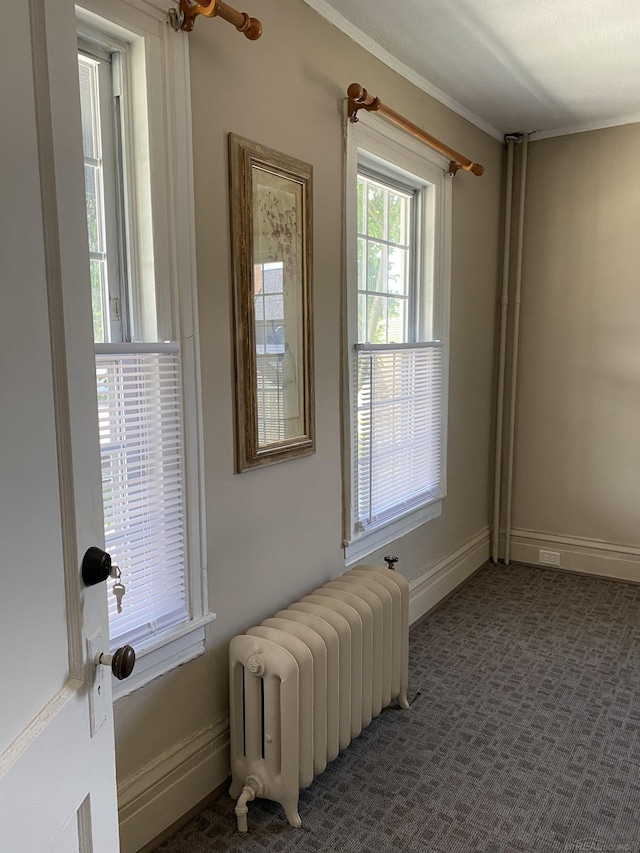 doorway featuring radiator heating unit and dark carpet