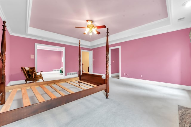 bedroom featuring carpet, ornamental molding, and a tray ceiling