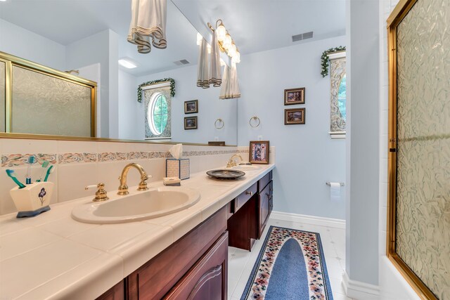 bathroom featuring dual sinks, tile flooring, vanity with extensive cabinet space, and backsplash