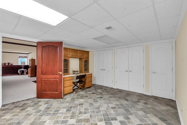 basement with tile flooring and a paneled ceiling