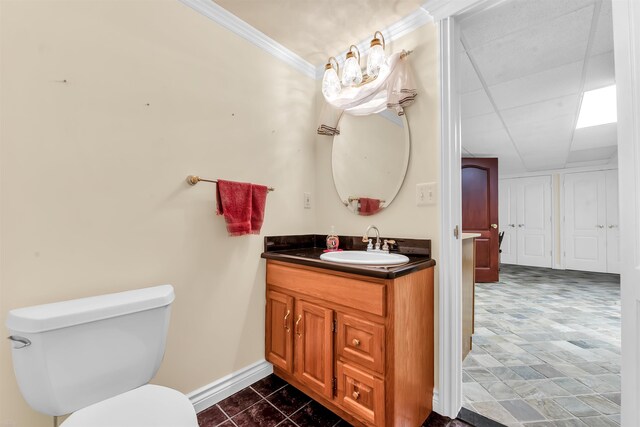 bathroom featuring tile flooring, vanity, toilet, and ornamental molding