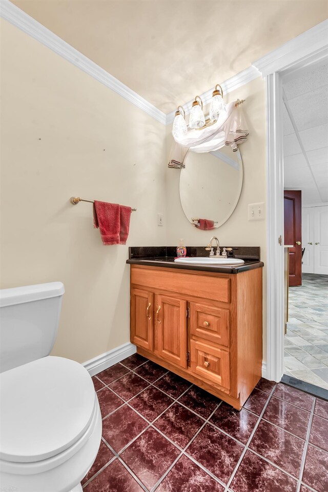 bathroom featuring tile floors, crown molding, toilet, and vanity