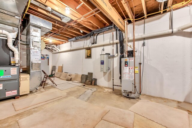 basement featuring electric water heater and gas water heater