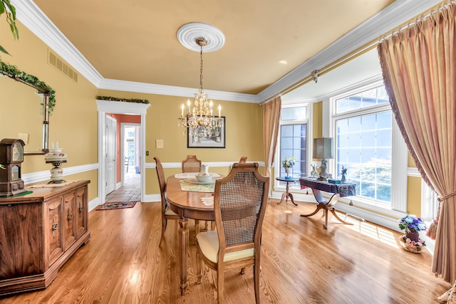 dining room featuring a notable chandelier, wood-type flooring, and crown molding