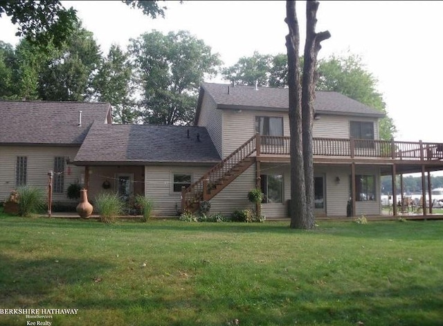 back of property featuring a wooden deck and a lawn