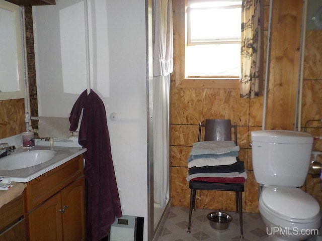 bathroom featuring walk in shower, tile flooring, vanity, and toilet