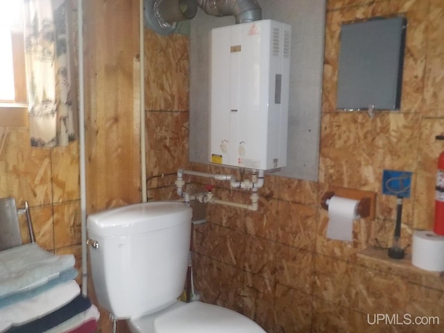 bathroom featuring tankless water heater and toilet