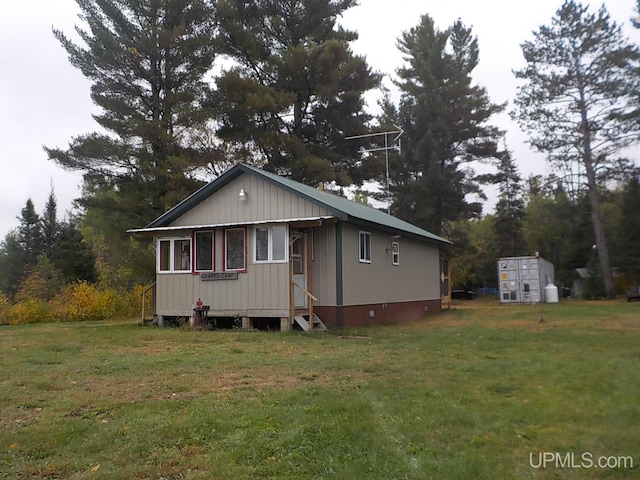 view of front of home featuring an outdoor structure and a front yard