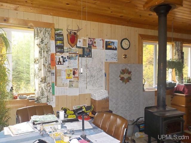 dining area with a wood stove and wood ceiling