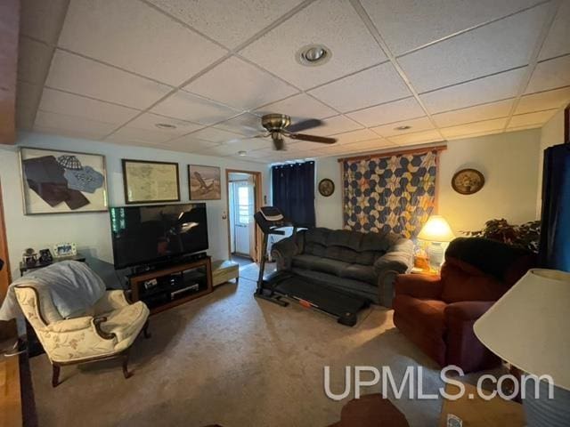 living room featuring ceiling fan and a drop ceiling