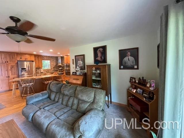 living room with ceiling fan and light hardwood / wood-style floors