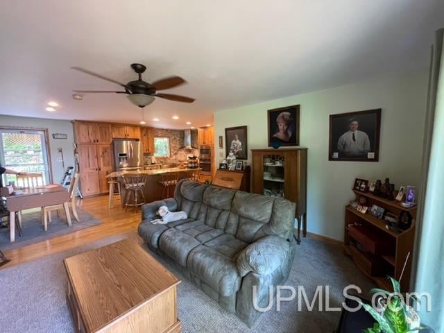 living room featuring ceiling fan and light hardwood / wood-style flooring