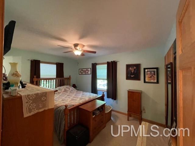 bedroom featuring light colored carpet and ceiling fan