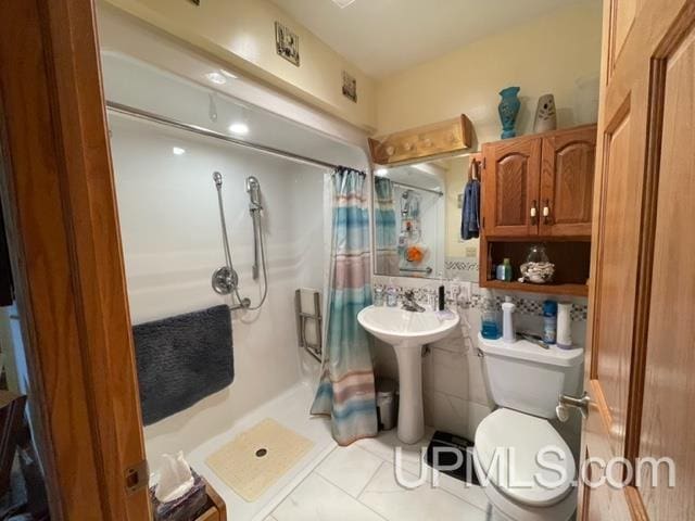 bathroom featuring tile patterned flooring, toilet, and a shower with curtain