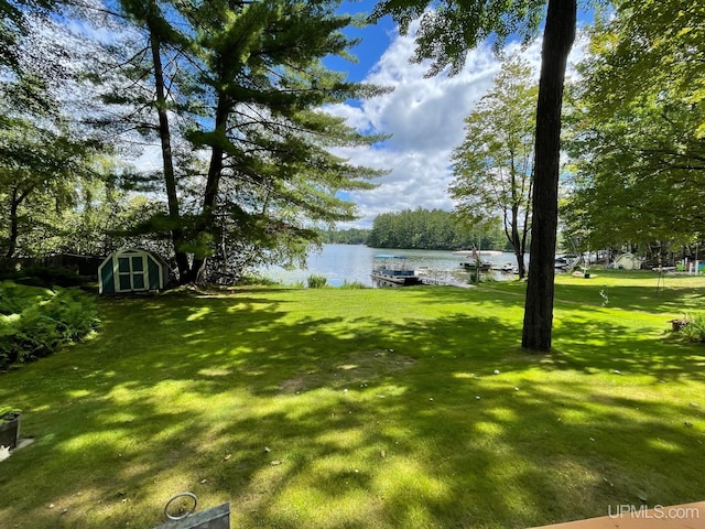 view of yard with a shed and a water view