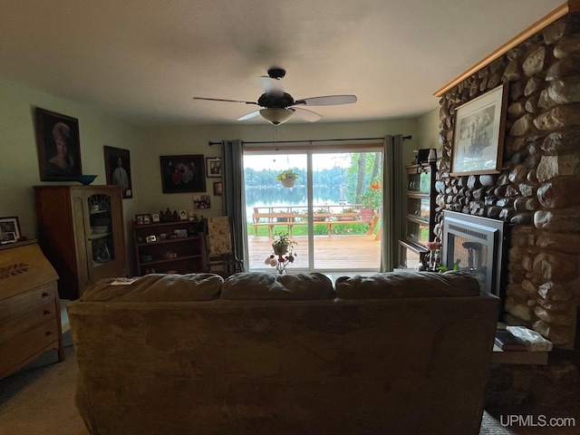 living room featuring a fireplace, carpet, and ceiling fan