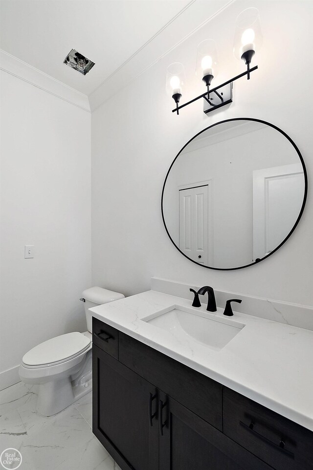 bathroom featuring toilet, vanity, baseboards, marble finish floor, and ornamental molding