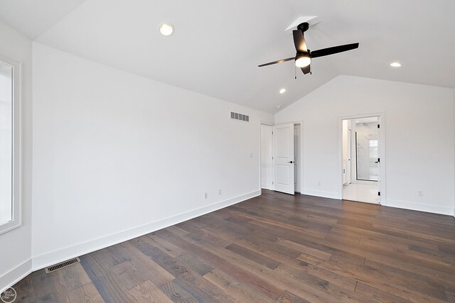 unfurnished bedroom featuring dark wood-style flooring, visible vents, vaulted ceiling, and baseboards